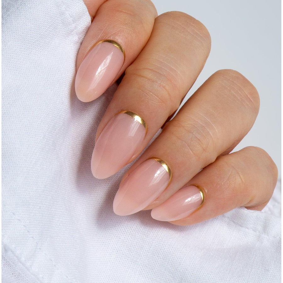 Elegant nude press-on nails with gold accent designs, offering a subtle yet glamorous touch.